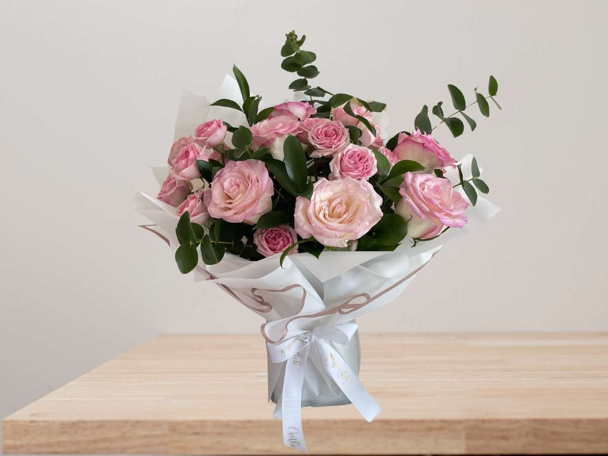 Elegant pink rose bouquet with fresh roses and greenery wrapped in luxury paper