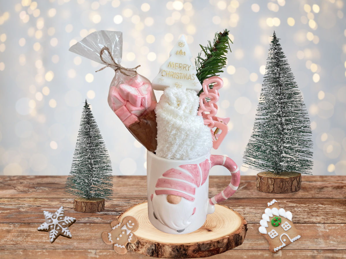 Christmas mug gift set with hot chocolate, marshmallows, socks, hair clip and festive decorations on wooden table