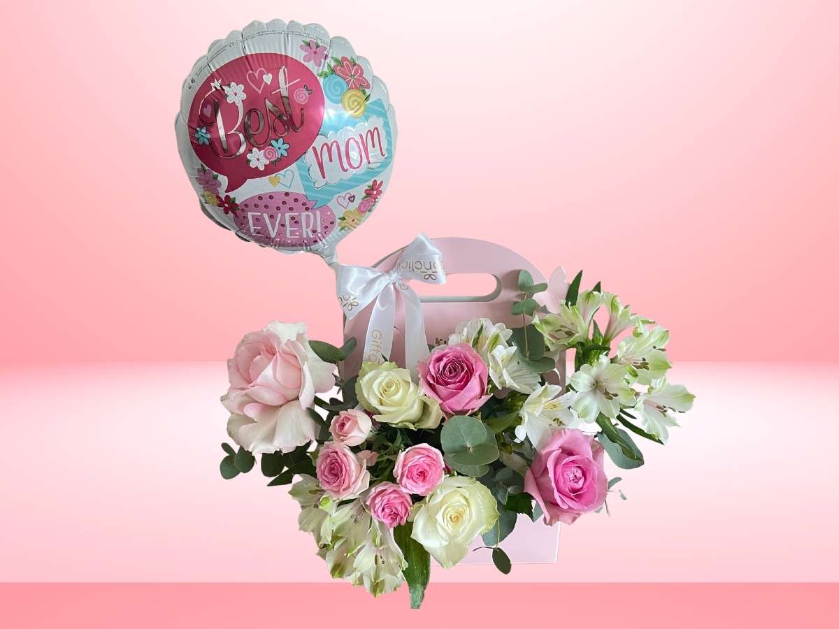 Floral arrangement with a 'Best Mom Ever' balloon on a pink background
