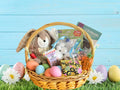 Easter basket with plush bunny, eggs, and books on a blue wooden background