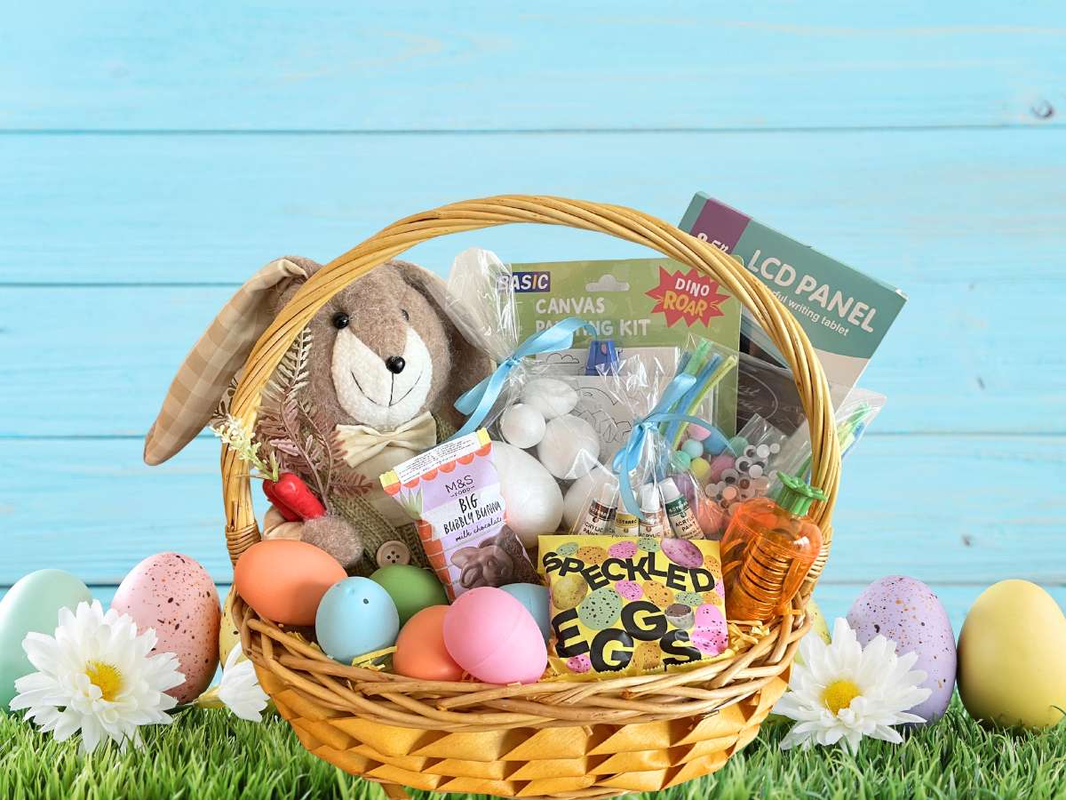 Easter basket with plush bunny, eggs, and books on a blue wooden background