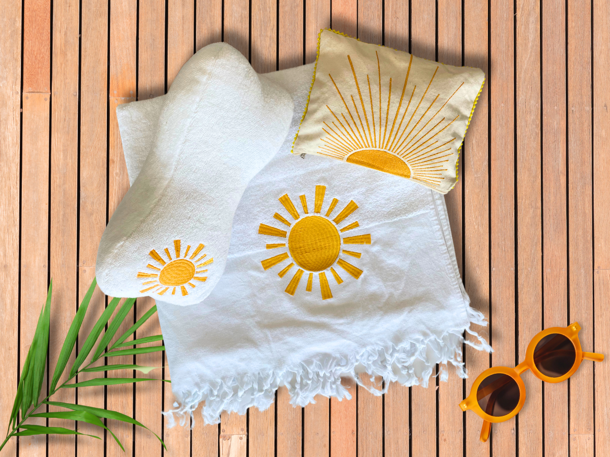 beach essentials set, beach towel, beach pillow, zippered pouch, sun motif embroidery, travel-ready beach kit, cotton beach towel, luxury beach accessory, summer beach set Dubai, beach day accessories, sun care pouch, beach lounging set