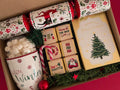 Gift box with Christmas themed mug, chocolate box, marshmallow ball and Christmas cracker